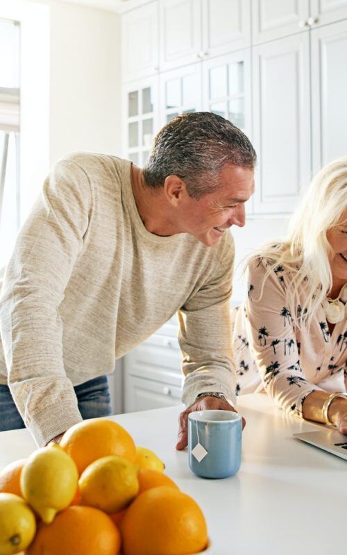 senior-couple-relaxing-in-a-kitchen-with-a-laptop